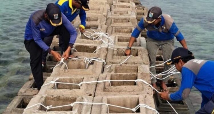 Pekerja menyelesaikan pembuatan tanggung pemecah gelombang di Pulau Kelapa Dua, Kepulauan Seribu. Foto Antara