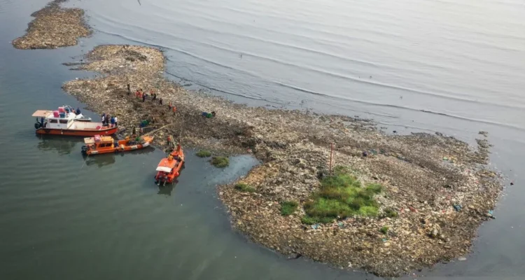 Ilustrasi foto udara petugas mengangkut sampah yang mengendap di perairan laut Jakarta, Rabu (3/6/2026). Foto Antara
