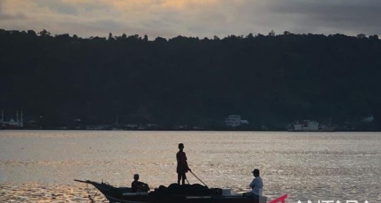 Nelayan Teluk Ambon, La Hamid (48) mendorong perahunya untuk melaut di Teluk Ambon. Foto Antara