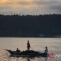 Nelayan Teluk Ambon, La Hamid (48) mendorong perahunya untuk melaut di Teluk Ambon. Foto Antara