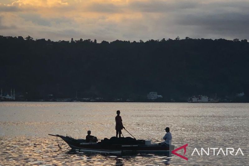 Nelayan Teluk Ambon, La Hamid (48) mendorong perahunya untuk melaut di Teluk Ambon. Foto Antara