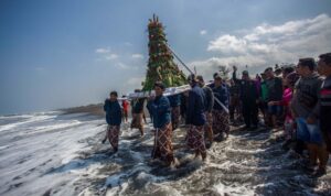 Abdi dalem membawa gunungan hasil bumi menuju pantai saat prosesi labuhan di Pantai Glagah, Kulon Progo, Yogyakarta, Rabu (17/7/2024). Tradisi yang digelar oleh Kadipaten Pakualaman yang rutin dilaksanakan pada bulan Muharram atau Suro tersebut melabuh (melarung) sejumlah sesaji dan barang milik KGPAA Paku Alam X sebagai bentuk rasa syukur keluarga besar Puro Pakualaman kepada Tuhan Yang Maha Esa. Foto Antara Abdi dalem membawa gunungan hasil bumi menuju pantai saat prosesi labuhan di Pantai Glagah, Kulon Progo, Yogyakarta, Rabu (17/7/2024). Tradisi yang digelar oleh Kadipaten Pakualaman yang rutin dilaksanakan pada bulan Muharram atau Suro tersebut melabuh (melarung) sejumlah sesaji dan barang milik KGPAA Paku Alam X sebagai bentuk rasa syukur keluarga besar Puro Pakualaman kepada Tuhan Yang Maha Esa. Foto Antara