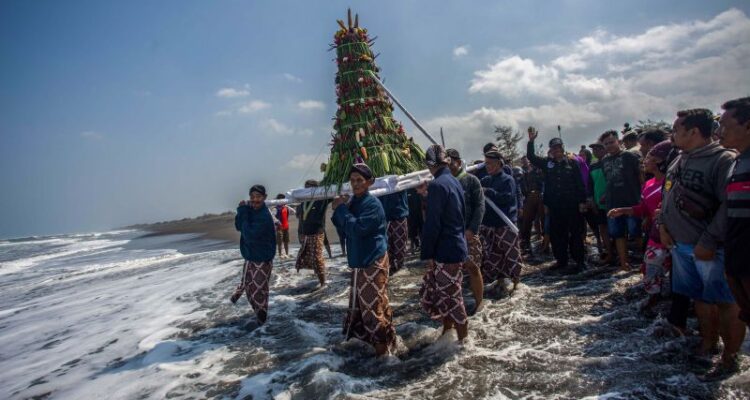 Abdi dalem membawa gunungan hasil bumi menuju pantai saat prosesi labuhan di Pantai Glagah, Kulon Progo, Yogyakarta, Rabu (17/7/2024). Tradisi yang digelar oleh Kadipaten Pakualaman yang rutin dilaksanakan pada bulan Muharram atau Suro tersebut melabuh (melarung) sejumlah sesaji dan barang milik KGPAA Paku Alam X sebagai bentuk rasa syukur keluarga besar Puro Pakualaman kepada Tuhan Yang Maha Esa. Foto Antara
