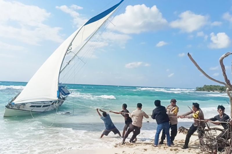 Aparat kepolisian dan warga menambatkan yacht tanpa pemilik yang terdampar di perairan Rote Ndao. Foto Antara Aparat kepolisian dan warga menambatkan yacht tanpa pemilik yang terdampar di perairan Rote Ndao. Foto Antara