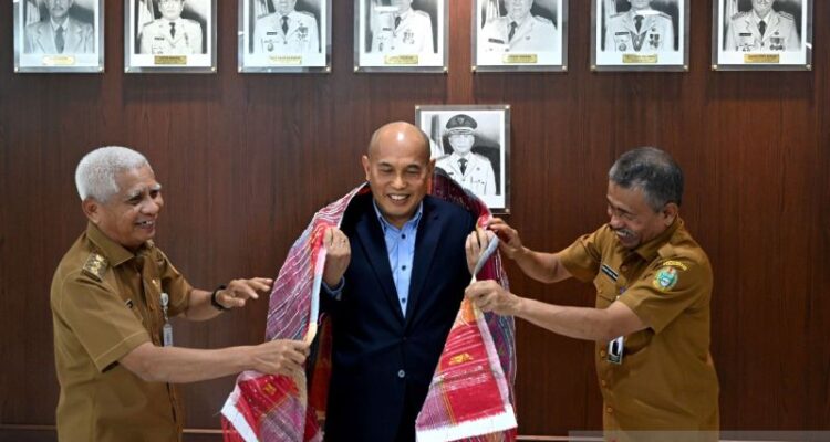 Wakil Gubernur Sumatera Utara Surya (kiri) memakai kain ulos di tubuh Konsul Jenderal RI Penang Malaysia Wanton Saragih Sidauruk (tengah) di Kantor Gubernur Sumut, Senin (6/7/2026). Foto Antara