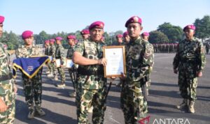 Panglima Korps Marinir (Pangkormar) Letnan Jenderal TNI (Mar) Endi Supardi memberi piagam penghargaan kepada salah satu prajurit Satgas Pengamanan Perbatasan (Pamtas) RI–PNG Mobile Yonif 10 Marinir di Lapangan Apel Brigif 1 Marinir, Kesatrian Marinir Hartono, Cilandak, Jakarta Selatan, Jumat (10/07/2026). Foto Antara
