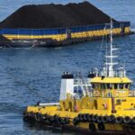 Kapal tunda menarik tongkang bermuatan batu bara menuju pembangkit listrik sebagai bagian dari layanan angkutan barang PT Pelni. Foto Antara