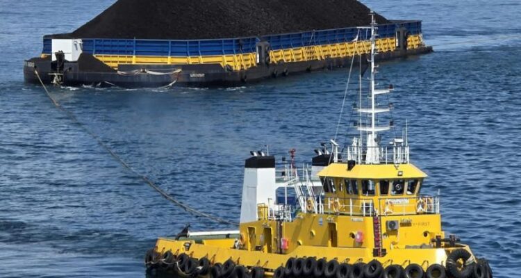 Kapal tunda menarik tongkang bermuatan batu bara menuju pembangkit listrik sebagai bagian dari layanan angkutan barang PT Pelni. Foto Antara
