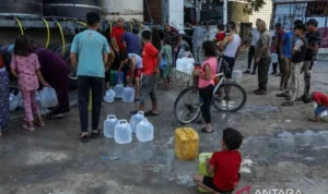 Warga Palestina mengisi wadah dengan air bersih yang didistribusikan melalui pasokan truk tangki di Khan Yunis, Gaza, Palestina, Senin (13/7/2026). Krisis air masih berlangsung akibat kerusakan parah pada infrastruktur dan sumur air yang disebabkan oleh serangan Israel. Warga Palestina mengisi wadah dengan air bersih yang didistribusikan melalui pasokan truk tangki di Khan Yunis, Gaza, Palestina, Senin (13/7/2026). Krisis air masih berlangsung akibat kerusakan parah pada infrastruktur dan sumur air yang disebabkan oleh serangan Israel. Sumber Foto: Antara