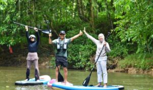 Kepala Kantor Wilayah Kemenham Provinsi Kaltim Umi Laila (kiri) bersama suami dan putrinya, di atas paddle board di SKM Samarinda setelah memungut sampah di sungai itu, Ahad (5/7). Foto Antara