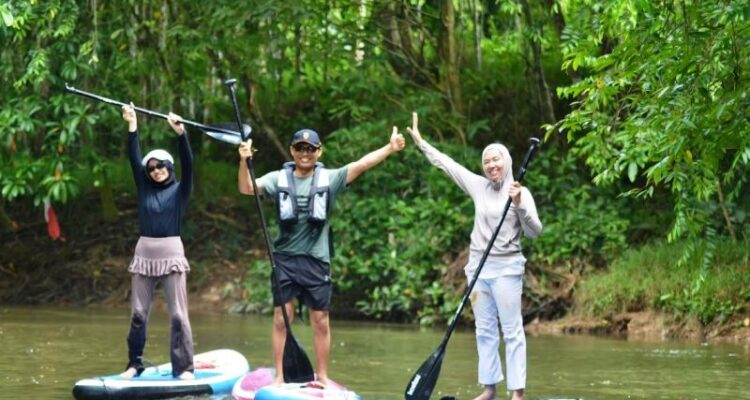 Kepala Kantor Wilayah Kemenham Provinsi Kaltim Umi Laila (kiri) bersama suami dan putrinya, di atas paddle board di SKM Samarinda setelah memungut sampah di sungai itu, Ahad (5/7). Foto Antara