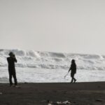 Wisatawan berfoto dengan latar belakang ombak besar yang menggulung di Pantai Parangtritis, Kalurahan Parangtritis, Kapanewon Kretek, Bantul, Daerah Istimewa Yogyakarta, Kamis (20/8/2026). Sumber foto: Antara