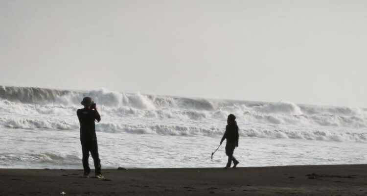 Wisatawan berfoto dengan latar belakang ombak besar yang menggulung di Pantai Parangtritis, Kalurahan Parangtritis, Kapanewon Kretek, Bantul, Daerah Istimewa Yogyakarta, Kamis (20/8/2026). Sumber foto: Antara