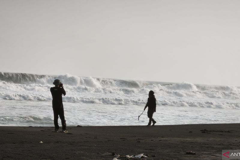 Wisatawan berfoto dengan latar belakang ombak besar yang menggulung di Pantai Parangtritis, Kalurahan Parangtritis, Kapanewon Kretek, Bantul, Daerah Istimewa Yogyakarta, Kamis (20/8/2026). Sumber foto: Antara Wisatawan berfoto dengan latar belakang ombak besar yang menggulung di Pantai Parangtritis, Kalurahan Parangtritis, Kapanewon Kretek, Bantul, Daerah Istimewa Yogyakarta, Kamis (20/8/2026). Sumber foto: Antara