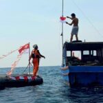 Pembangian bendera Merah Putih kepada nelayan oleh personel Kantor SAR Natuna di Perairan Pulau Bunguran ada Rabu 12/8/2026). Sumber foto: Antara