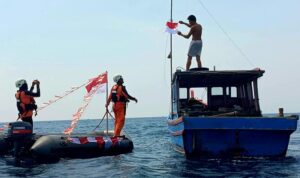 Pembangian bendera Merah Putih kepada nelayan oleh personel Kantor SAR Natuna di Perairan Pulau Bunguran ada Rabu 12/8/2026). Sumber foto: Antara
