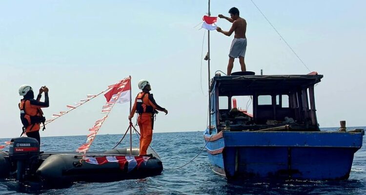 Pembangian bendera Merah Putih kepada nelayan oleh personel Kantor SAR Natuna di Perairan Pulau Bunguran ada Rabu 12/8/2026). Sumber foto: Antara