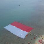 Sejumlah penyelam gabungan BPBD, Basarnas, TNI AL, dan komunitas penyelam membentangkan bendera Merah Putih di perairan laut Merak, Kota Cilegon, Banten, Sabtu. Sumber foto: Antara