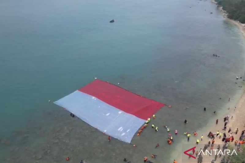 Sejumlah penyelam gabungan BPBD, Basarnas, TNI AL, dan komunitas penyelam membentangkan bendera Merah Putih di perairan laut Merak, Kota Cilegon, Banten, Sabtu. Sumber foto: Antara