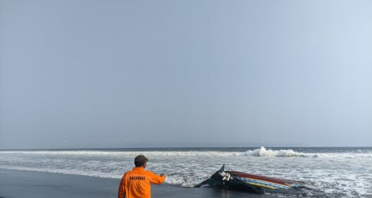 Petugas Basarnas Pos SAR Jember menunjukkan bangkai perahu yang terbalik di Pantai Paseban Jember, Rabu (19/8/2026). Sumber foto: Antara