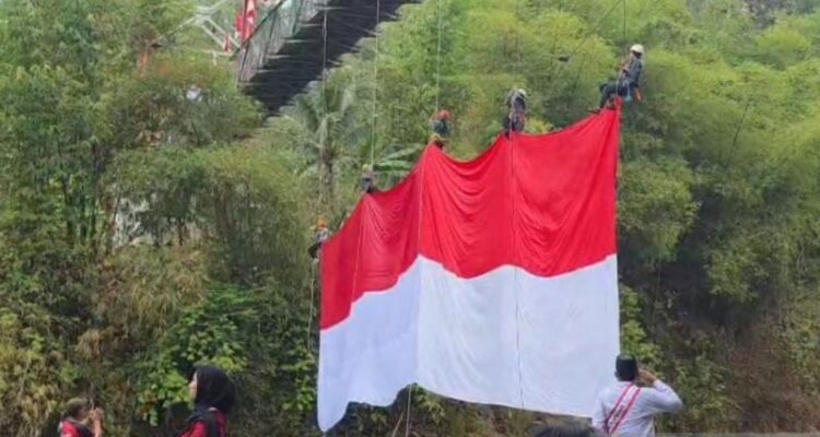 Sejumlah warga mengibarkan bendera merah putih berukuran 20x10 meter dalam rangka memperingati Hari Kemerdekaan ke-81 Republik Indonesia di Jembatan Sungai Citanduy perbatasan Kota Tasikmalaya dengan Kabupaten Ciamis, Jawa Barat, Senin (17/8/2026). Sumber foto: Antara
