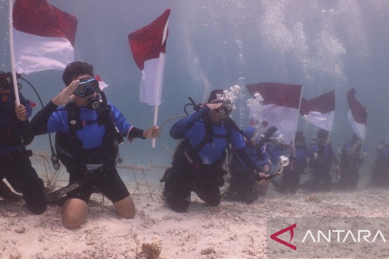 Para penyelam menggelar upacara pengibaran bendera Merah Putih dalam momentum peringatan HUT Ke-81 RI di bawah laut Pulau Maratua, Kabupaten Berau, Kaltim, Senin (17/8/2026). Sumber foto: Antara