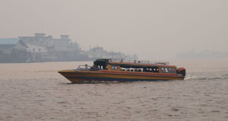 Kapal motor melintasi Sungai Kapuas yang diselimuti kabut asap tebal di Pontianak, Kalimantan Barat, Minggu (23/8/2026). Sumber foto: Antara