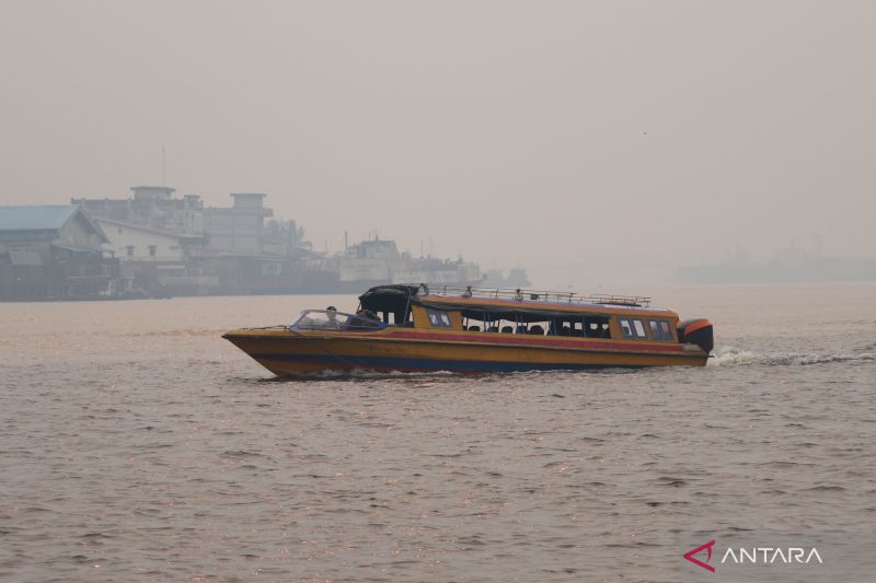 Kapal motor melintasi Sungai Kapuas yang diselimuti kabut asap tebal di Pontianak, Kalimantan Barat, Minggu (23/8/2026). Sumber foto: Antara