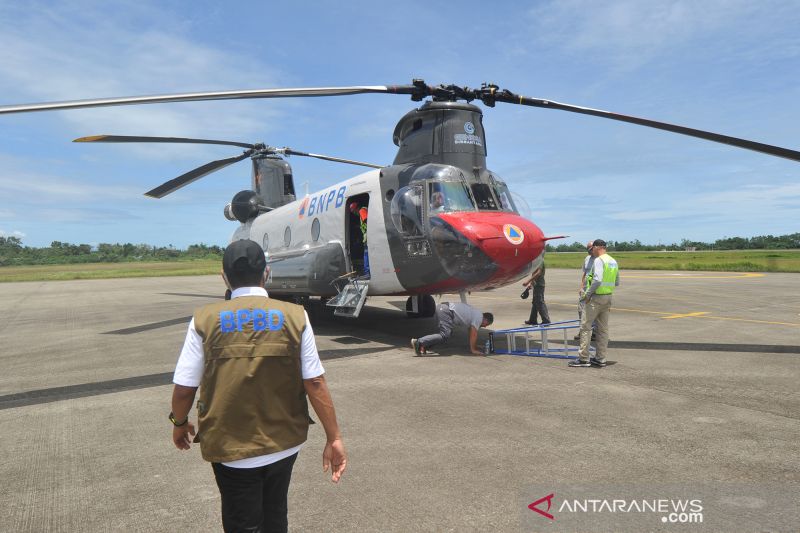 Kalaksa BPBD Sumbar, Erman Rahman (kiri) mengecek kondisi Helikopter Chinook CH-47D, saat berada di Bandara Internasional Minangkabau (BIM), Padangpariaman, Sumatera Barat, Jumat (11/9/2020). BNPB mendatangkan Helikopter Chinook CH-47D dari Amerika Serikat (AS) dan akan berada di provinsi itu hingga sepekan ke depan untuk distribusi peralatan, APD, dan logistik bencana alam di antaranya tenda pengungsian, perahu karet, pelampung, masker, dan hazmat. Sumber foto: Antara Kalaksa BPBD Sumbar, Erman Rahman (kiri) mengecek kondisi Helikopter Chinook CH-47D, saat berada di Bandara Internasional Minangkabau (BIM), Padangpariaman, Sumatera Barat, Jumat (11/9/2020). BNPB mendatangkan Helikopter Chinook CH-47D dari Amerika Serikat (AS) dan akan berada di provinsi itu hingga sepekan ke depan untuk distribusi peralatan, APD, dan logistik bencana alam di antaranya tenda pengungsian, perahu karet, pelampung, masker, dan hazmat. Sumber foto: Antara