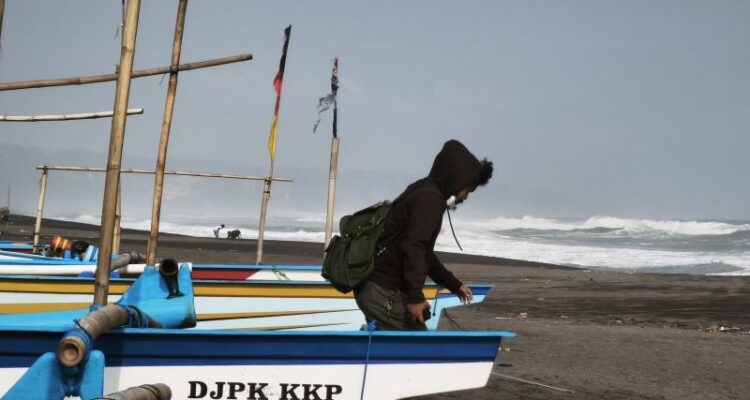 Seorang wisatawan berjalan di antara kapal nelayan di Pantai Depok, Kalurahan Parangtritis, Kabupaten Bantul, Daerah Istimewa Yogyakarta, Kamis (20/8/2026). Sumber foto: Antara
