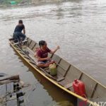 Dua perempuan mengendarai perahu ketinting setelah membeli 5 liter pertalite di APMS/SPBU Kompak di Kecamatan Long Pahangai, Kabupaten Mahakam Ulu, Kaltim, Rabu (21/10/2026). Sumber foto: Antara