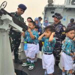 Anak buah KRI Karotang-872 memberi kesempatan kepada murid-murid TK untuk memegang senapan mesin ringan di kapal tersebut. Sumber foto: Dispen Kodaeral XII