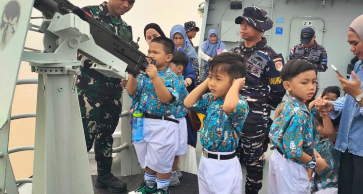 Anak buah KRI Karotang-872 memberi kesempatan kepada murid-murid TK untuk memegang senapan mesin ringan di kapal tersebut. Sumber foto: Dispen Kodaeral XII